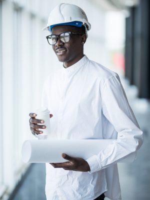 young afro american engineer with blue prints in front of panora